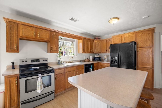 58 Mcclendon Ln, Russell Springs, KY 42642 - kitchen featuring black appliances, a sink, light countertops, and light wood-style flooring
