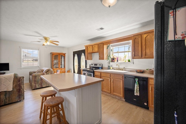 58 Mcclendon Ln, Russell Springs, KY 42642 - kitchen featuring black appliances, a sink, light wood-type flooring, plenty of natural light, and a textured ceiling