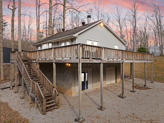 back of house with a garage, stairway, a deck, and a carport