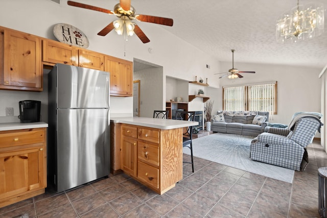kitchen featuring light countertops, a ceiling fan, freestanding refrigerator, a peninsula, and open floor plan