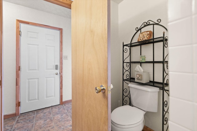bathroom with baseboards and toilet