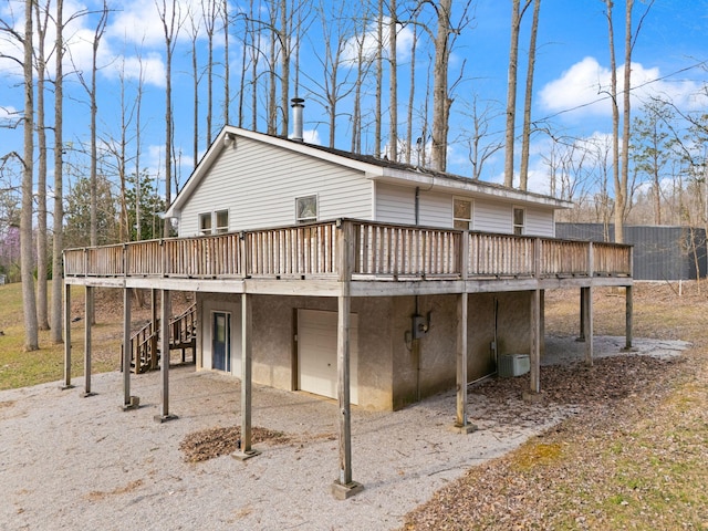 rear view of house with central AC unit, a wooden deck, and stairway