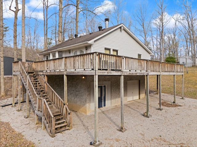 rear view of property featuring stairway, a carport, and a wooden deck