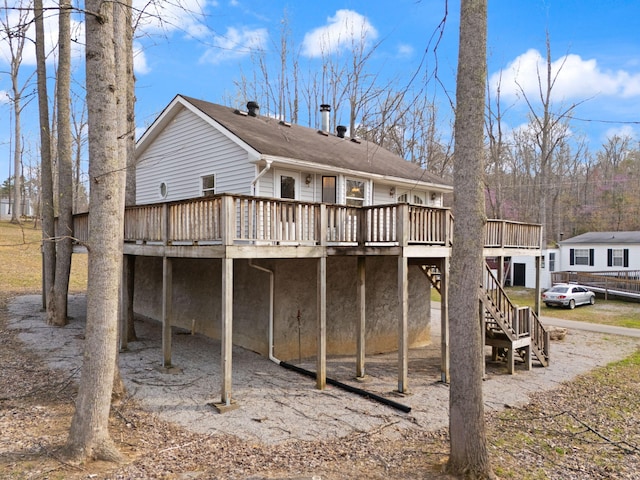 rear view of house featuring stairs and a wooden deck