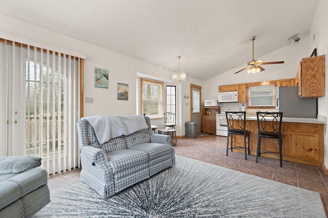 living area featuring ceiling fan with notable chandelier, lofted ceiling, and tile patterned floors