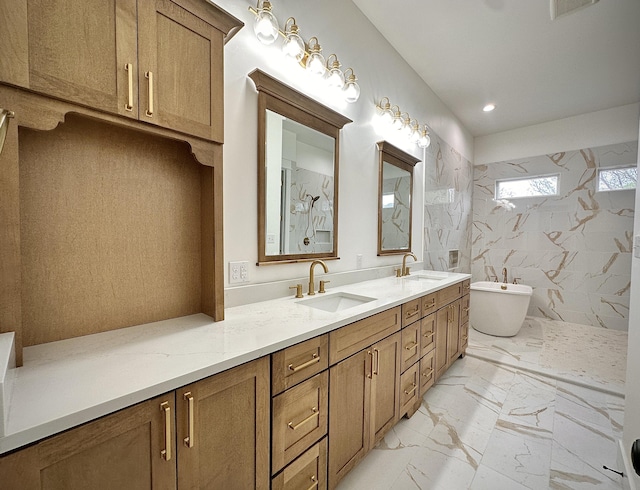 full bath with double vanity, a freestanding bath, a sink, and marble finish floor
