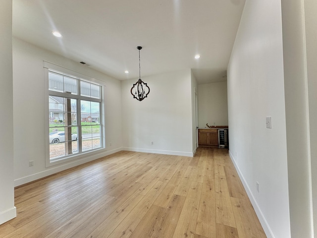 unfurnished dining area with visible vents, baseboards, a chandelier, light wood-style floors, and recessed lighting