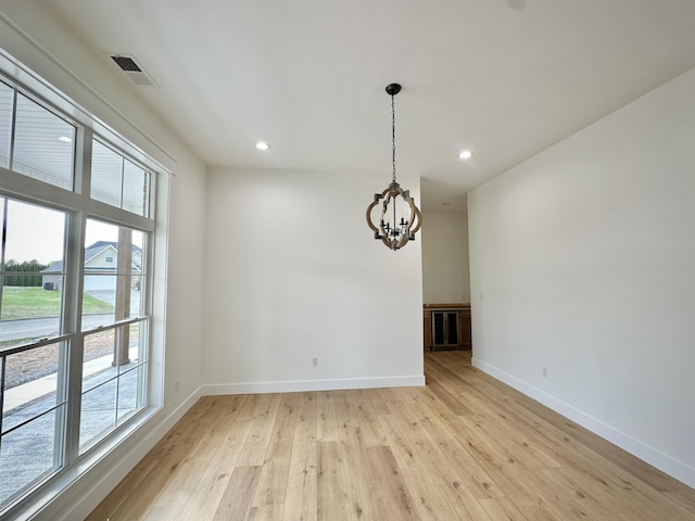 unfurnished dining area featuring an inviting chandelier, visible vents, light wood-style floors, baseboards, and recessed lighting