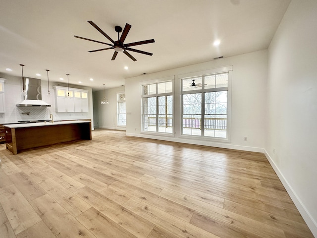 unfurnished living room with recessed lighting, a ceiling fan, light wood-style floors, and baseboards