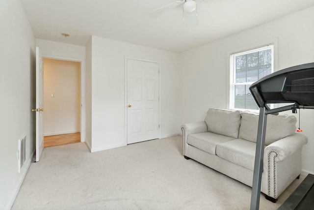 interior space featuring light carpet, baseboards, ceiling fan, and visible vents