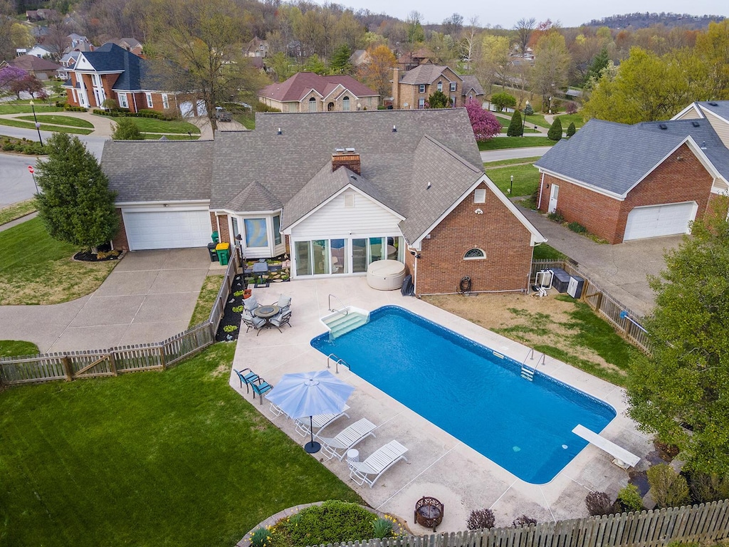 view of swimming pool with a patio area, a fenced in pool, a fenced backyard, a residential view, and a lawn