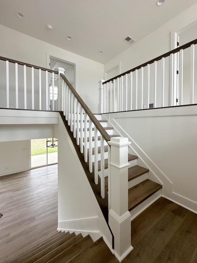 stairs with baseboards, visible vents, wood finished floors, and recessed lighting