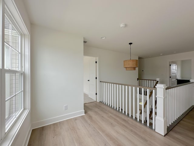 unfurnished room featuring baseboards and light wood-style floors