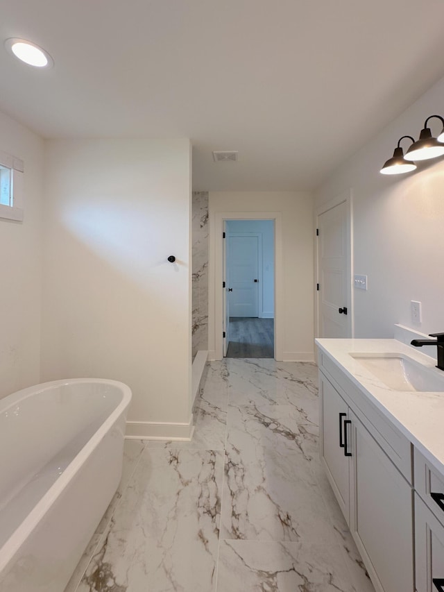 bathroom with vanity, a freestanding tub, baseboards, marble finish floor, and a walk in shower
