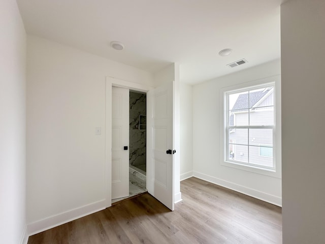 unfurnished bedroom with baseboards, visible vents, and wood finished floors