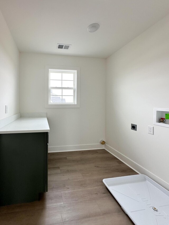 clothes washing area featuring visible vents, washer hookup, baseboards, wood finished floors, and electric dryer hookup