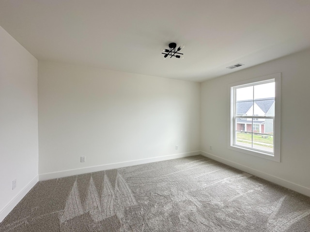 unfurnished room with carpet floors, baseboards, and visible vents