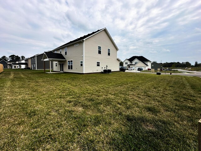 view of side of home featuring central air condition unit and a yard