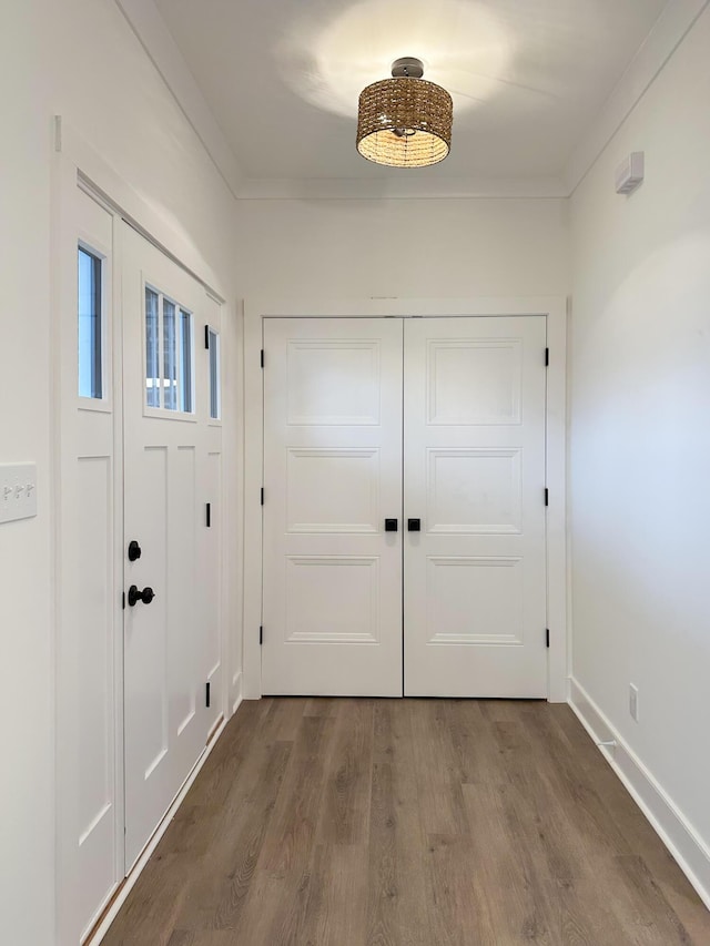 foyer with baseboards, wood finished floors, and crown molding
