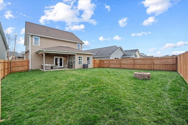 back of house with an outdoor fire pit, a fenced backyard, a patio, and a lawn
