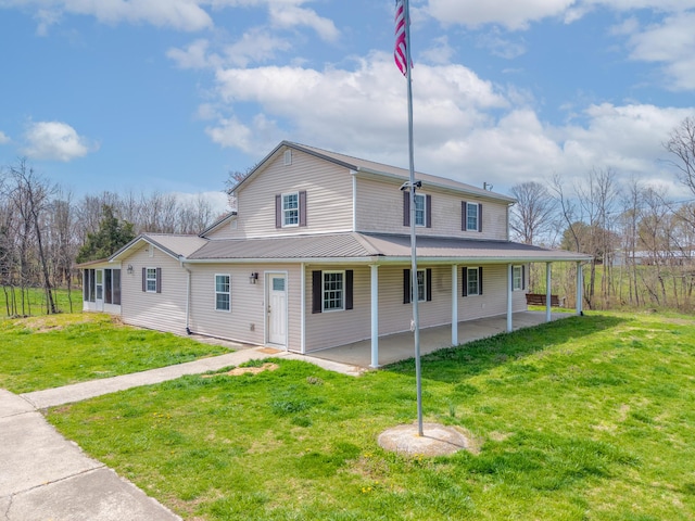 farmhouse with a patio, a sunroom, metal roof, and a front lawn