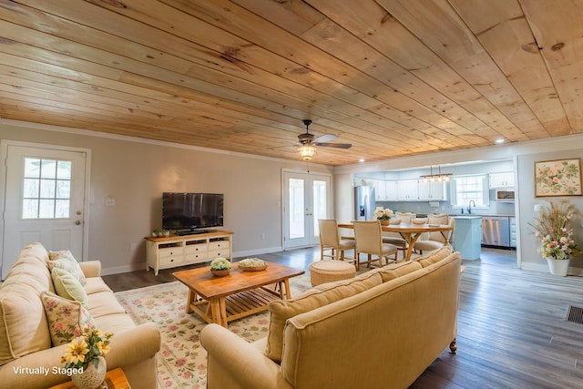 living room featuring ornamental molding, wood finished floors, a ceiling fan, and wooden ceiling