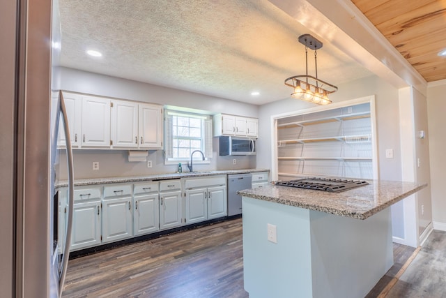 kitchen featuring stainless steel appliances, a textured ceiling, a sink, dark wood-style floors, and white cabinets