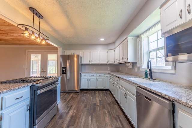 kitchen featuring french doors, dark wood-style flooring, stainless steel appliances, a sink, and white cabinets
