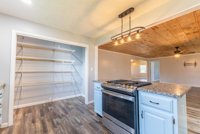 kitchen with a ceiling fan, hanging light fixtures, stainless steel range with gas stovetop, baseboards, and dark wood-style flooring
