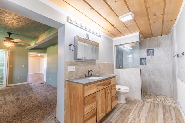 bathroom with toilet, a walk in shower, vanity, wood ceiling, and ceiling fan