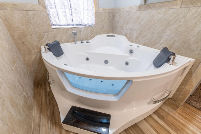 full bathroom with tile walls and a whirlpool tub