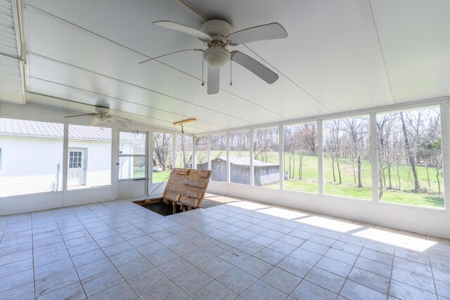 unfurnished sunroom featuring a ceiling fan