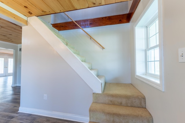 staircase featuring wood ceiling, plenty of natural light, and wood finished floors