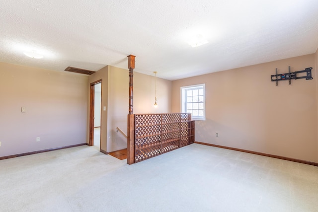empty room with carpet flooring, a textured ceiling, and visible vents