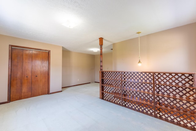 carpeted spare room with baseboards and a textured ceiling
