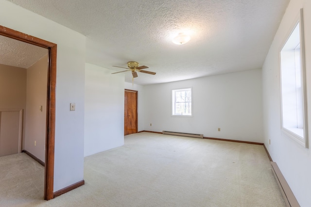 carpeted empty room with a baseboard radiator, a textured ceiling, baseboards, and a ceiling fan