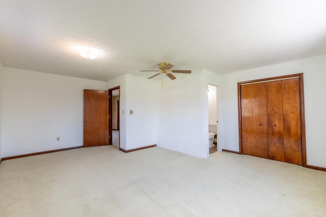 unfurnished bedroom featuring a ceiling fan, baseboards, a closet, and light colored carpet