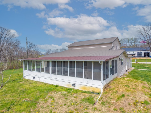 view of side of home featuring a sunroom, crawl space, a yard, and metal roof