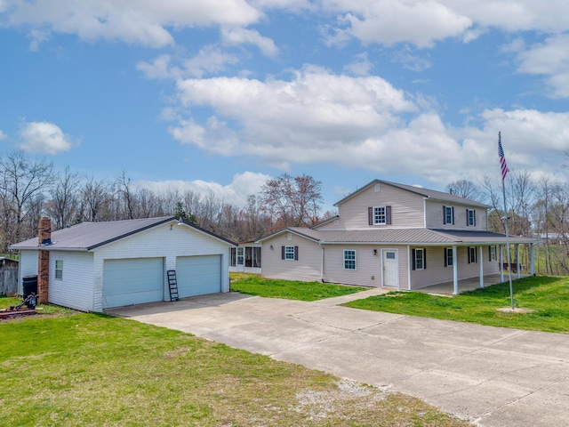 view of front of house with a front yard, an outbuilding, a garage, and metal roof