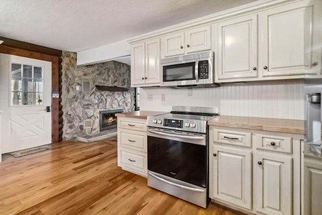 675 Indian Cave Subdivision Rd, Monticello, KY 42633 - kitchen featuring appliances with stainless steel finishes, light wood-style flooring, light countertops, and a fireplace