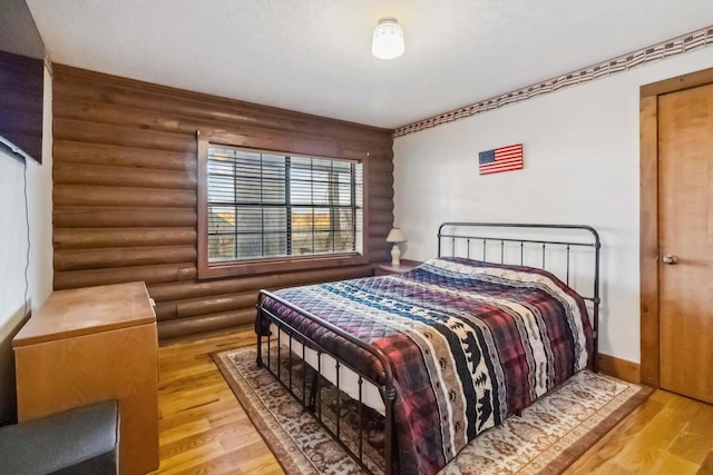 675 Indian Cave Subdivision Rd, Monticello, KY 42633 - bedroom featuring log walls, wood finished floors, and baseboards