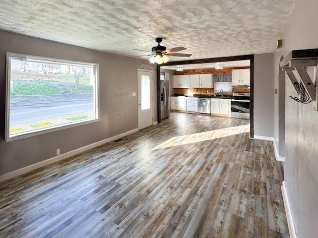 247 Mt Sterling Ave, Flemingsburg, KY 41041 - unfurnished living room featuring baseboards, a textured ceiling, a sink, a ceiling fan, and wood finished floors