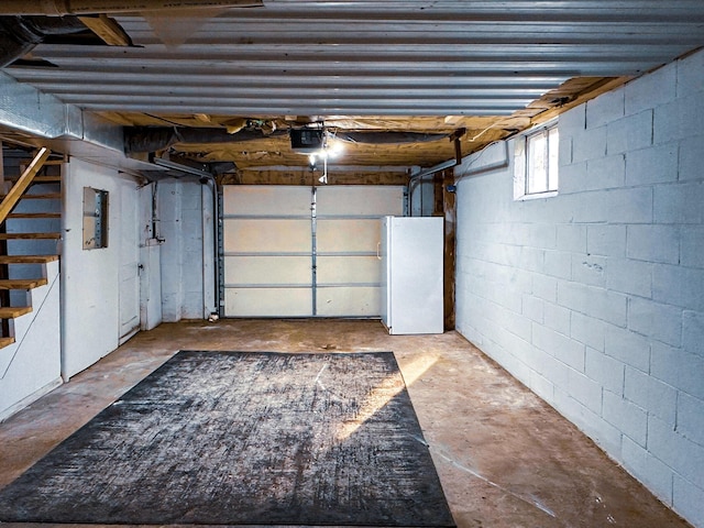 247 Mt Sterling Ave, Flemingsburg, KY 41041 - garage with concrete block wall, electric panel, a garage door opener, and freestanding refrigerator