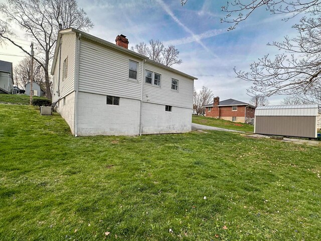 247 Mt Sterling Ave, Flemingsburg, KY 41041 - rear view of property with a lawn, a chimney, an outdoor structure, and a shed