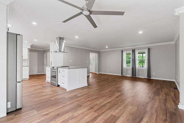 kitchen with appliances with stainless steel finishes, wall chimney range hood, open floor plan, ceiling fan, and recessed lighting