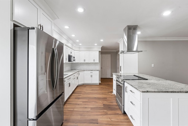 kitchen featuring stainless steel appliances, exhaust hood, ornamental molding, light wood-style flooring, and light stone countertops