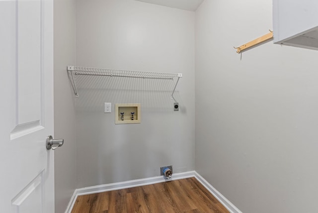 washroom with hookup for a washing machine, electric dryer hookup, dark wood-style floors, and baseboards