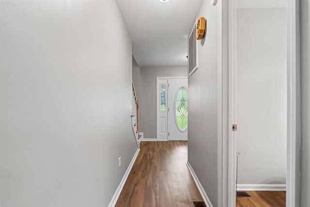 doorway with wood finished floors and baseboards