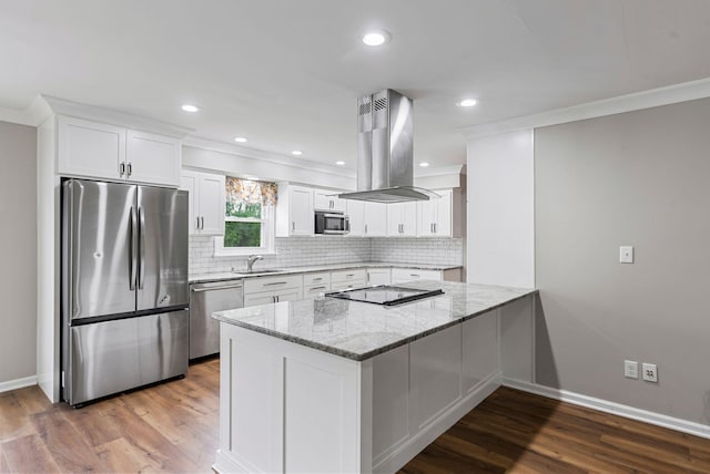 kitchen featuring stainless steel appliances, island exhaust hood, crown molding, light stone counters, and decorative backsplash