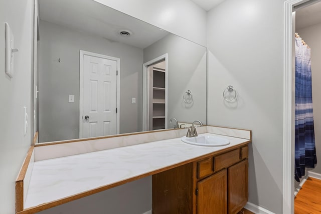 bathroom with vanity, wood finished floors, and baseboards